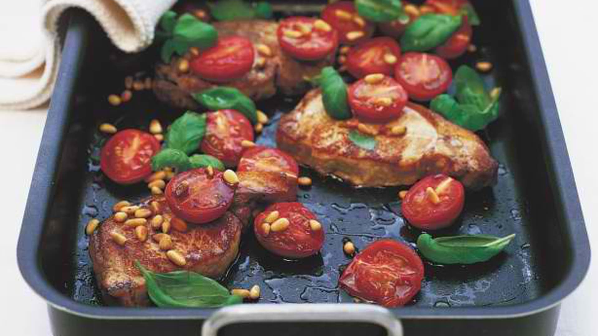 Roast pork steaks with tomatoes and pine nuts